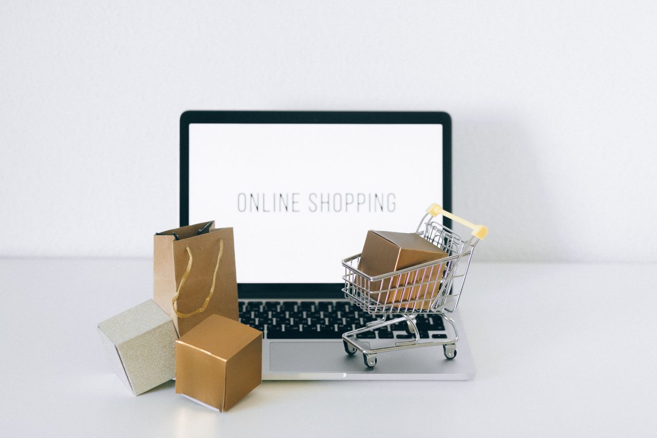heros-img Laptop displaying online shopping with boxes and cart, representing ecommerce.